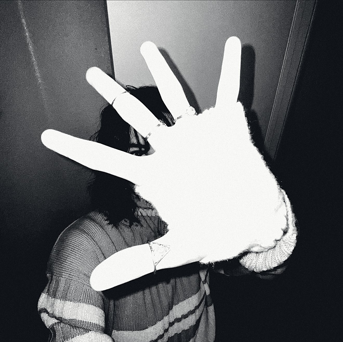 Raine, holding a hand up to the camera.